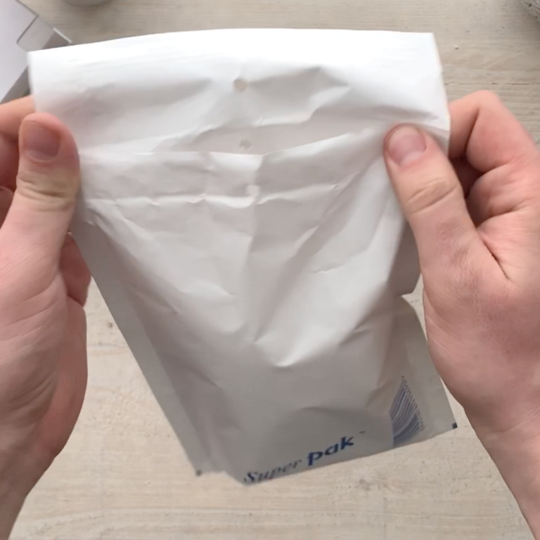 Placing the packed watch into a padded envelope